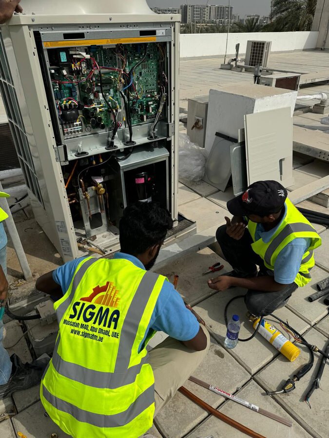 SIGMA technicians servicing electrical panel